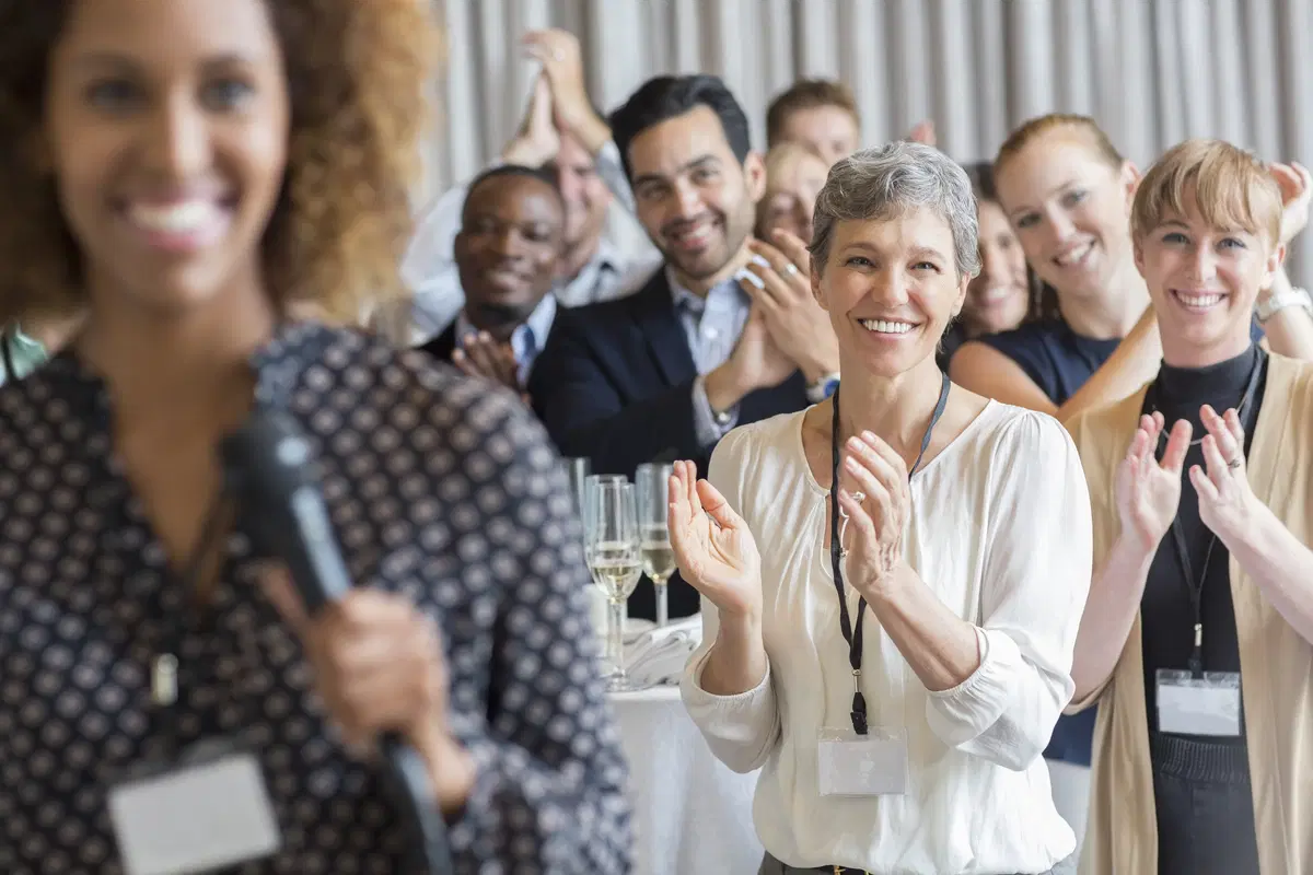 Group applauding at conference — HR and benefits compliance regulatory training