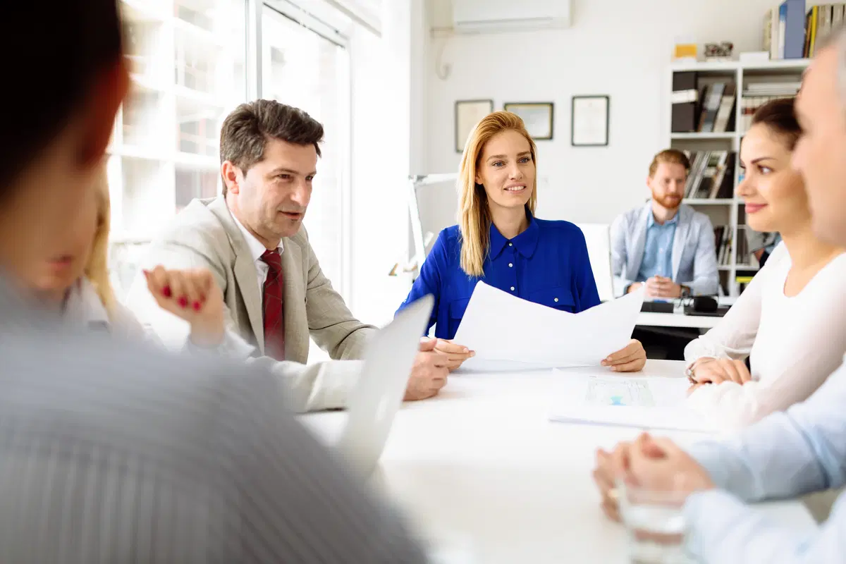 HR team meeting around conference table — open enrollment planning discussion